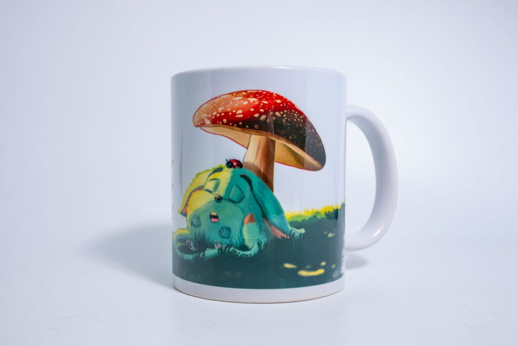 Mug Loomi MURU avec Loomi bleu assis sous un grand champignon rouge